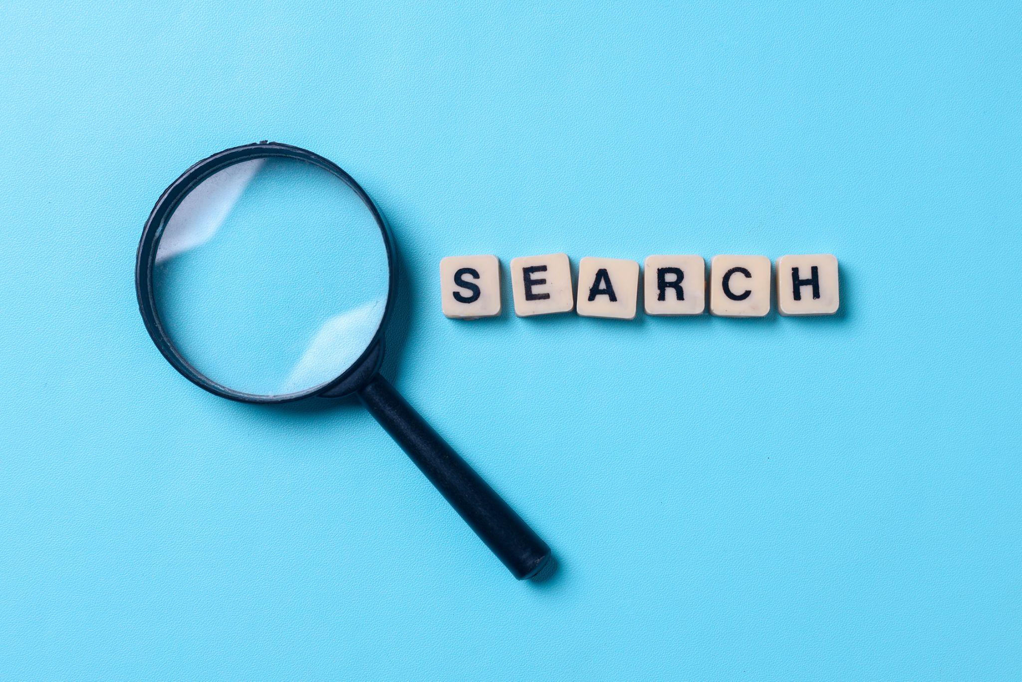 magnifying glass next to tiles spelling out the word ‘search’