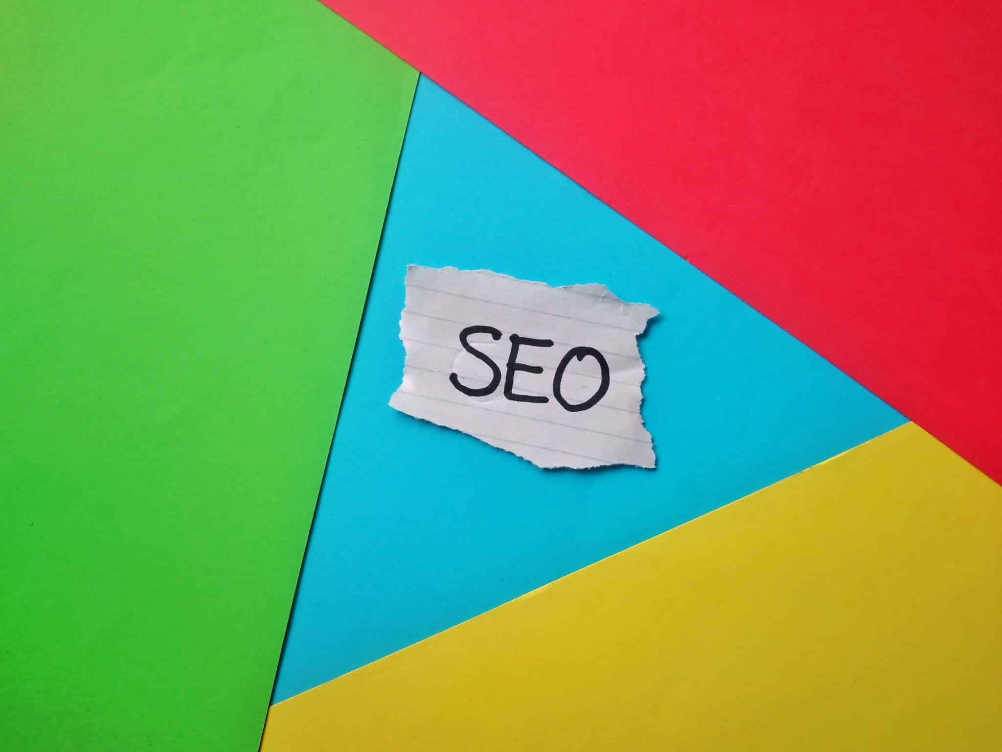 SEO written on a piece of torn paper on colorful background